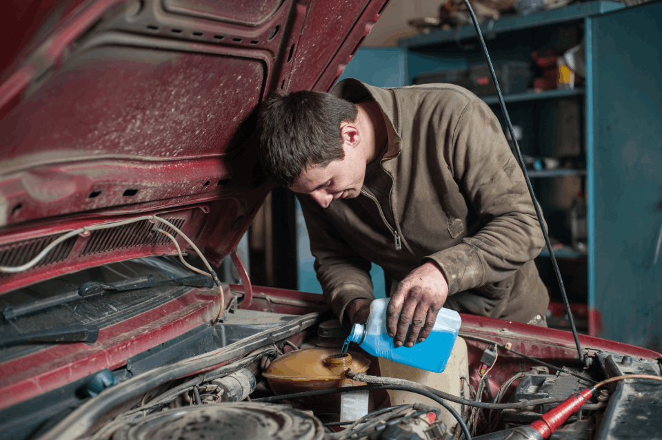 Worker performing maintenance for vehicle at an automotive garage