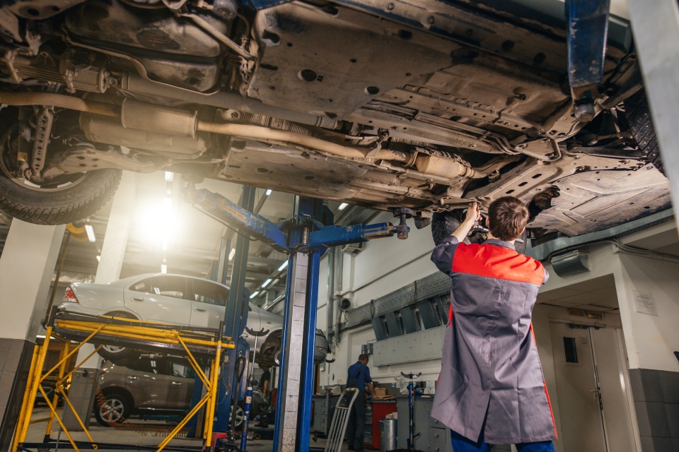 Worker performing repairs for a vehicle at the garage